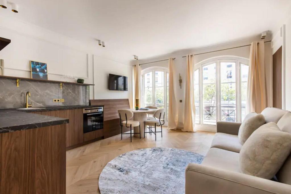 une cuisine et un salon avec un canapé et une table dans l'établissement Central&Spacious 2BD Apart for 6, à Paris