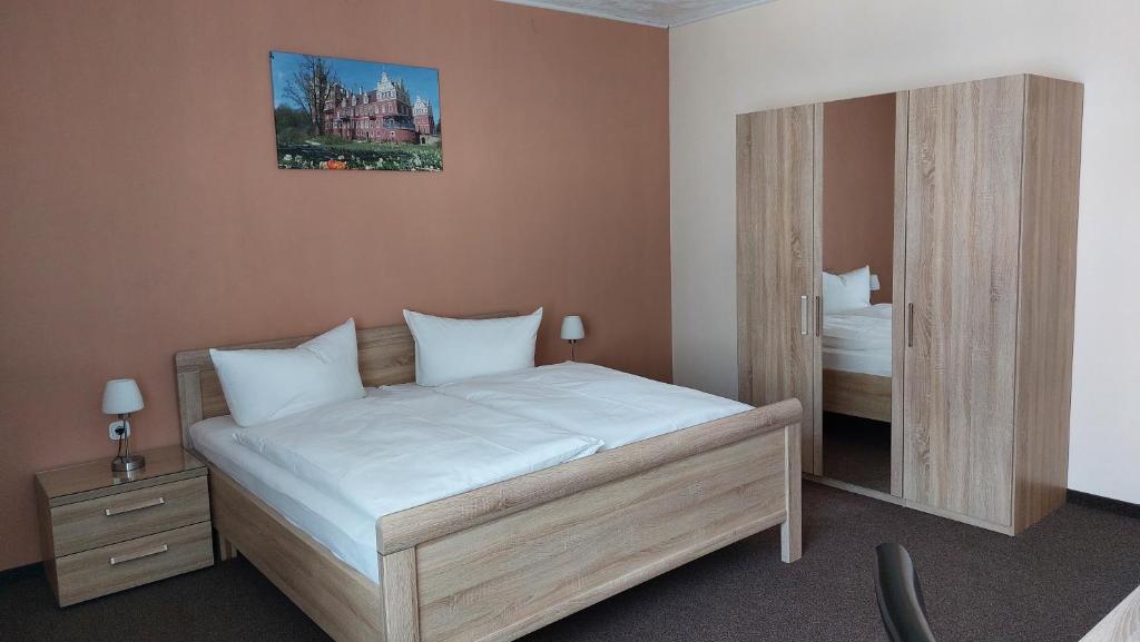 Dormitorio pequeño con cama y espejo en Pension Am Park, en Bad Muskau