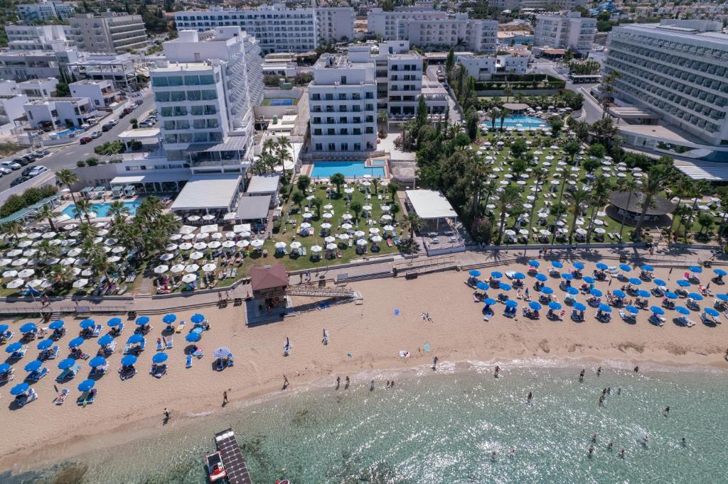 an aerial view of a beach with umbrellas and chairs at Iliada Beach Hotel in Protaras