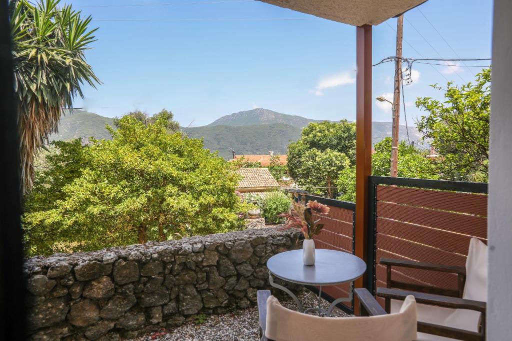 a patio with a table and chairs and a stone wall at Angela's flat studio - Dassia Corfu in Kato Korakiana