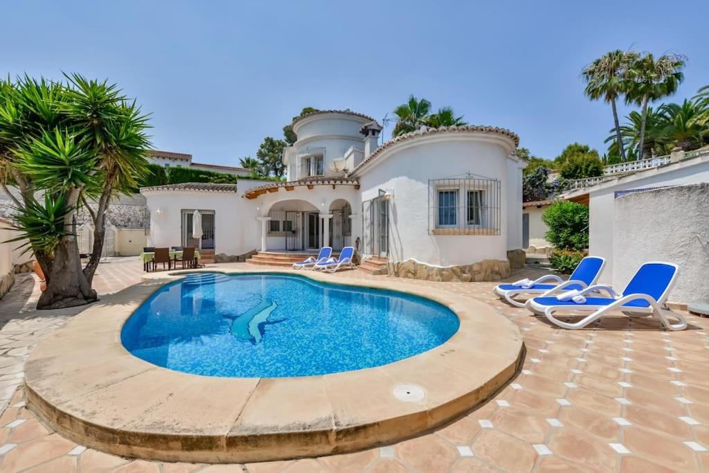 a swimming pool in front of a house at Villas Guzman - Sebastian in Moraira