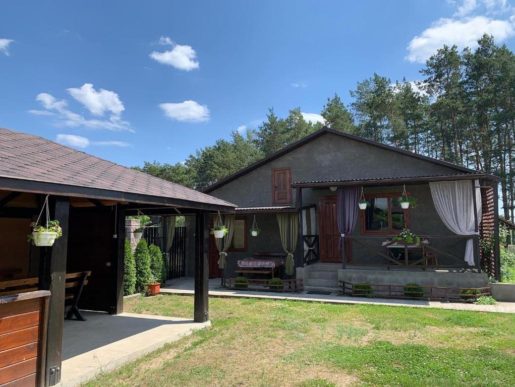 a small house with a porch and a patio at Садиба «Під ліском» in Pulʼmo