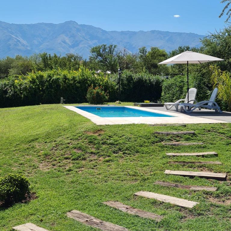 a swimming pool with a chair and an umbrella at Altos de San Blas in San Javier