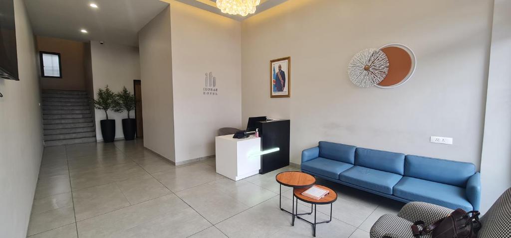 a waiting room with a blue couch and a table at Ixoras Hotel Lemba in Kinshasa