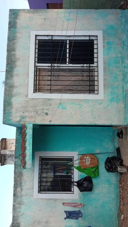 a building with a window and some hats on it at Casa kansasiti in Kanasín