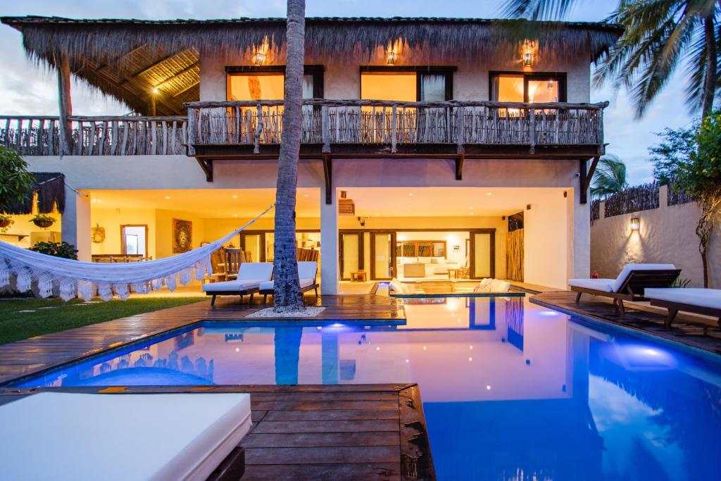 a villa with a swimming pool and a house at Casa Elea in Jericoacoara