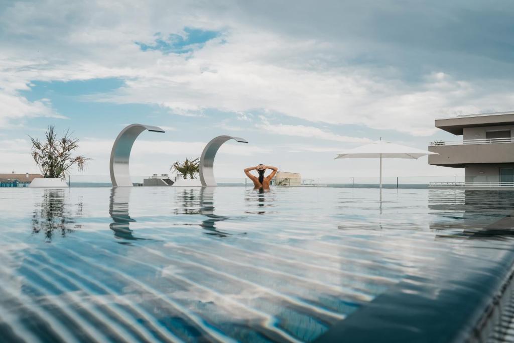 una persona in piedi in acqua in una piscina di J44 Lifestyle Hotel a Lido di Jesolo