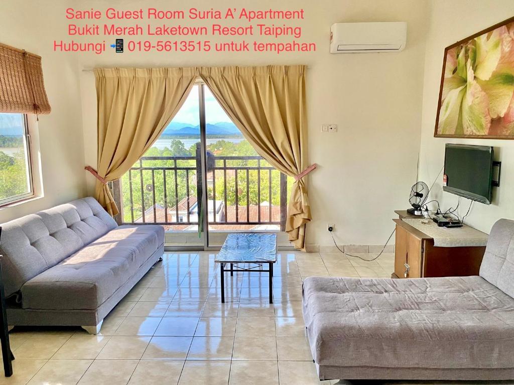 a living room with a couch and a tv at Sanie Guest Room Suria A' Apartment, Bukit Merah Laketown Resort in Kampong Kubu Gajah