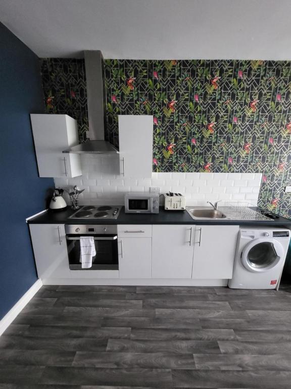 a kitchen with a sink and a washing machine at City Centre Studios 3 in Leicester