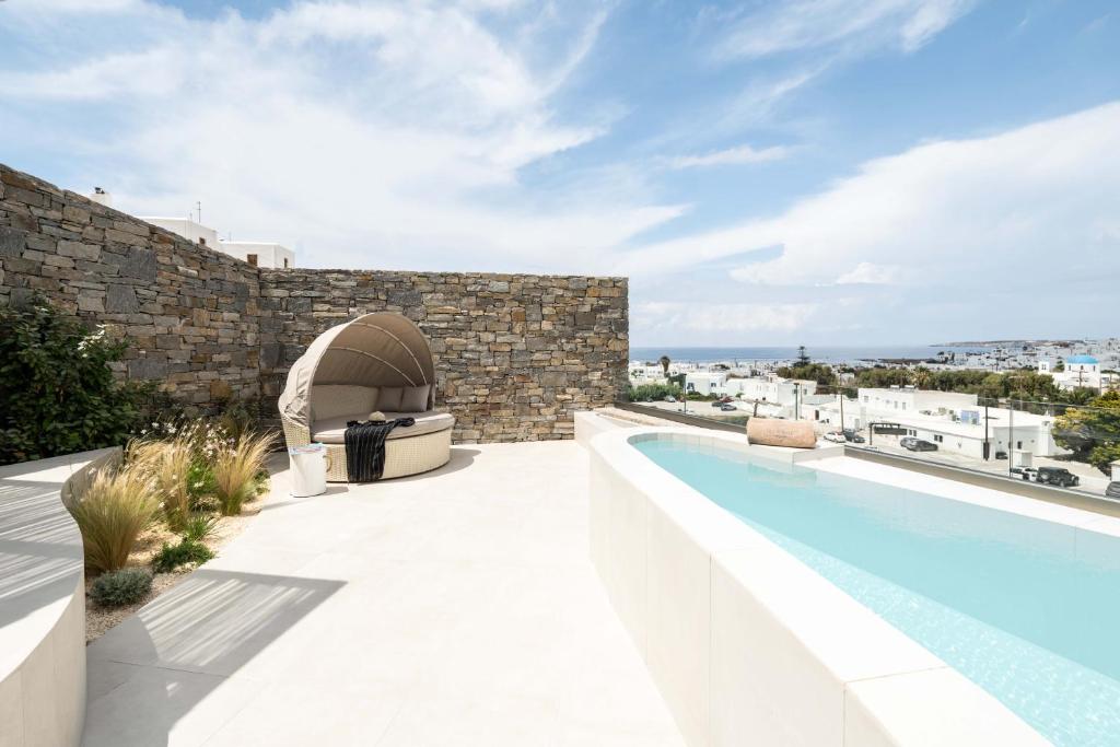 an outdoor patio with a swimming pool next to a building at Aura Suites Paros in Naousa