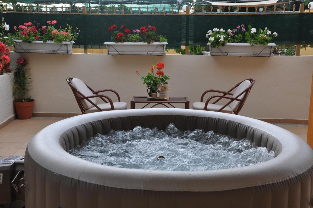 a water fountain on a balcony with chairs and flowers at Manos House Hersonisos in Hersonissos