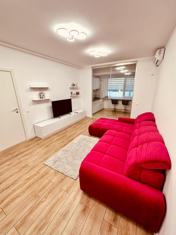 a red couch sitting in a living room at Avangarde Apartment in Bucharest
