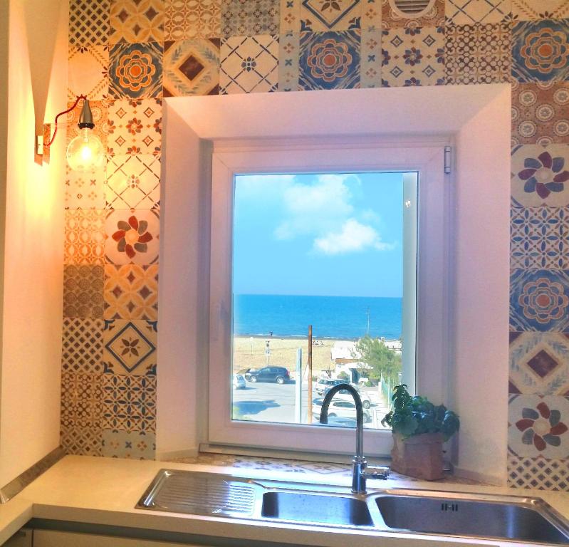 a kitchen sink with a window with a view of the ocean at Bettina's wonderful flat in Riccione