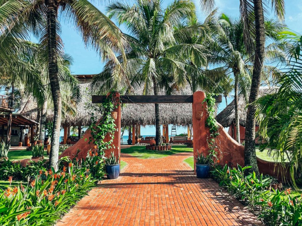 a pathway leading to a resort with palm trees at El Sitio Village in Playa Venao