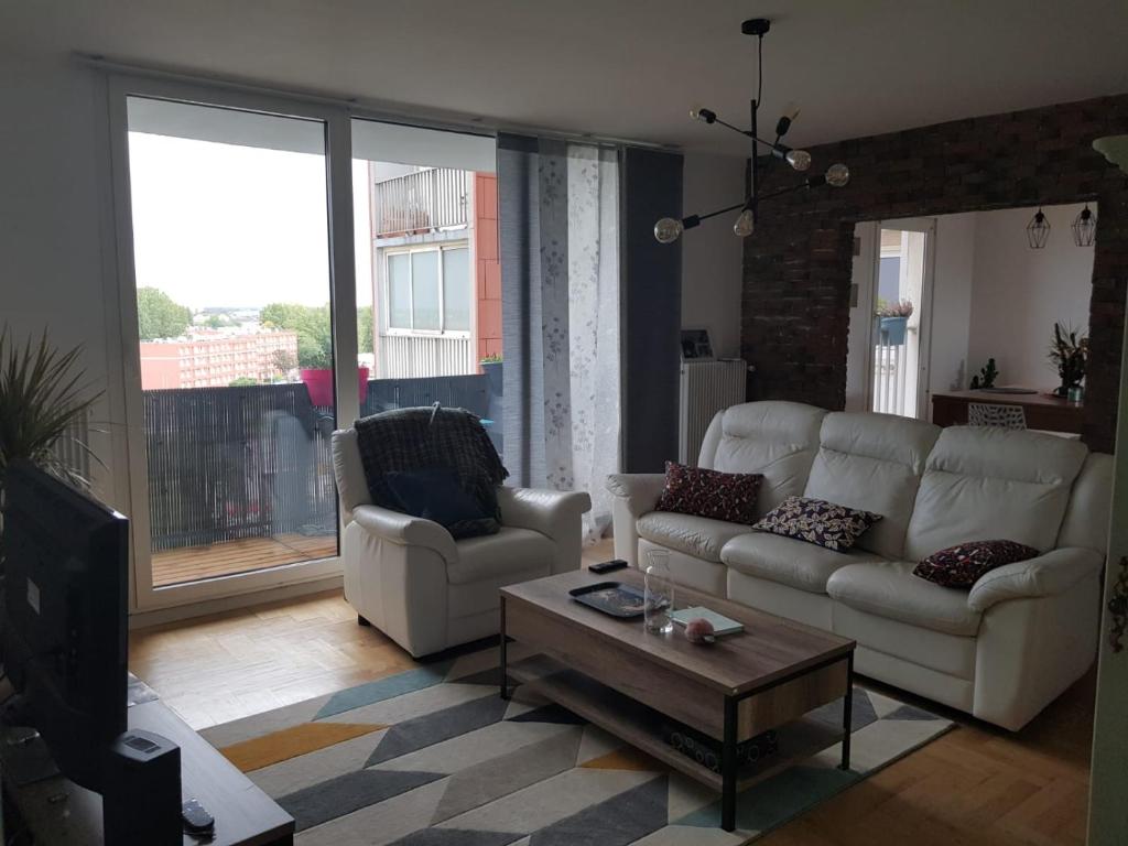 un salon avec deux canapés et une table basse dans l'établissement Bel appartement spacieux et lumineux, à Dunkerque