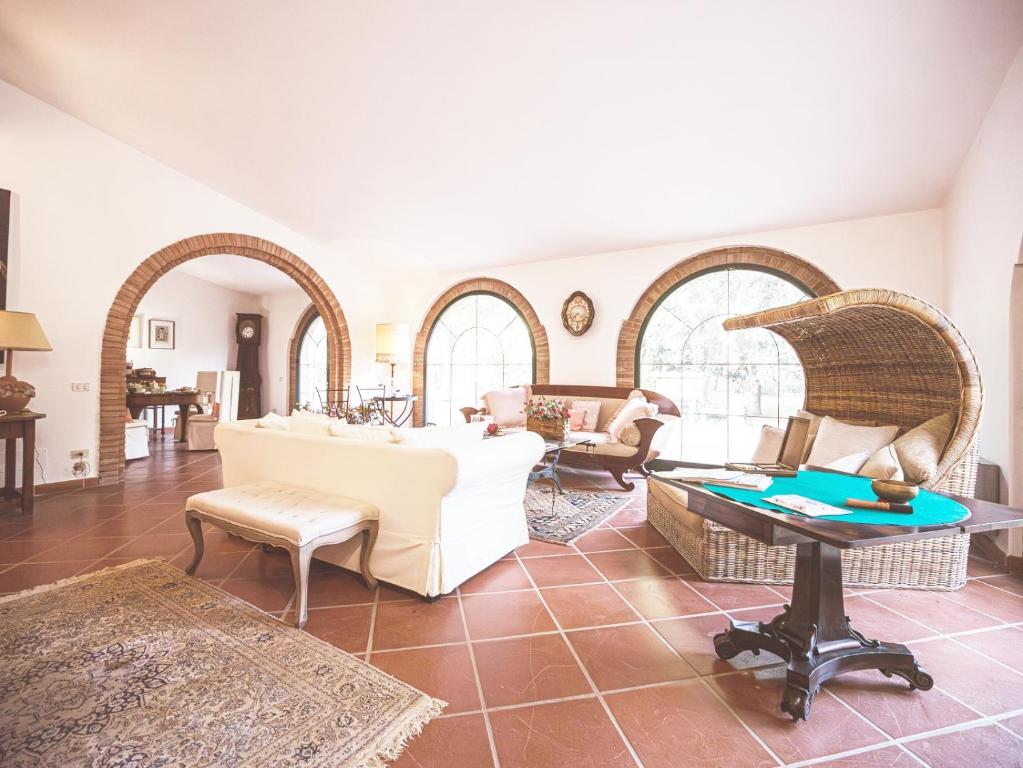 sala de estar con muebles blancos y mesa en Relais Casale Il Poggetto VILLA PAOLA en Cecina