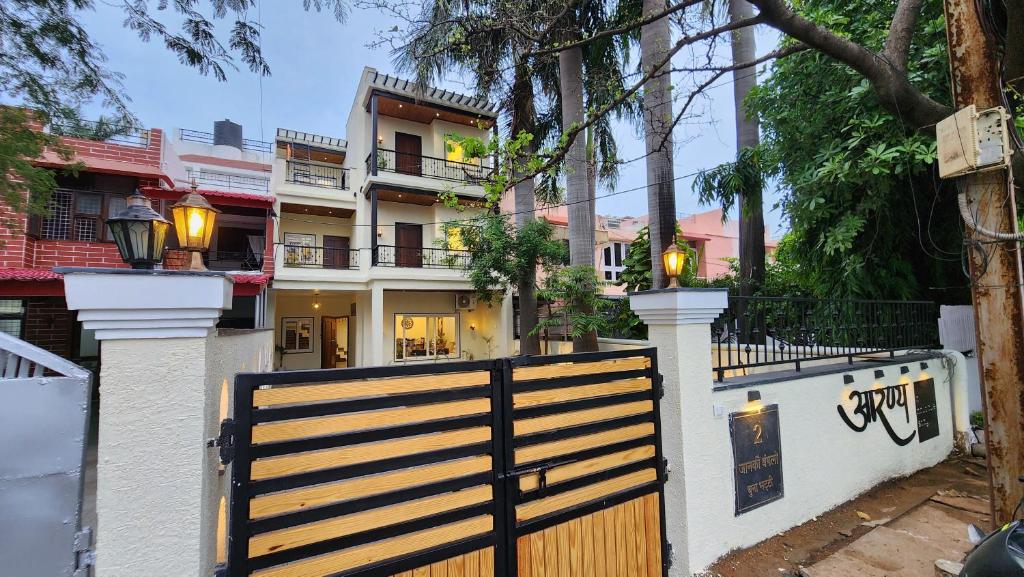a house with a wooden gate and a fence at Aaranya - A Boutique Stay in Bhopal