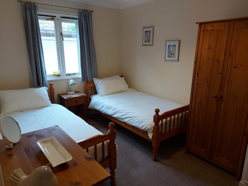 a bedroom with two beds and a table with a table at The Chalets in Eskdale