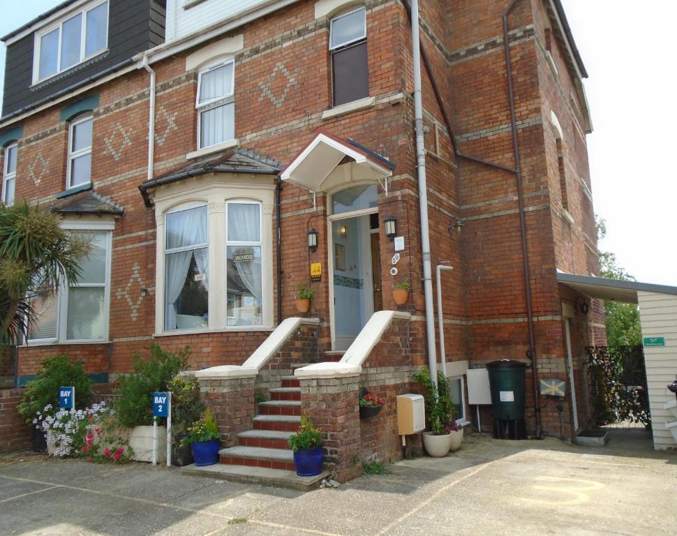 a brick house with a staircase leading to the front door at The Florian in Weymouth