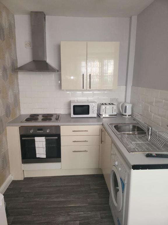 a small kitchen with a stove and a sink at City Centre Studios 1 in Leicester