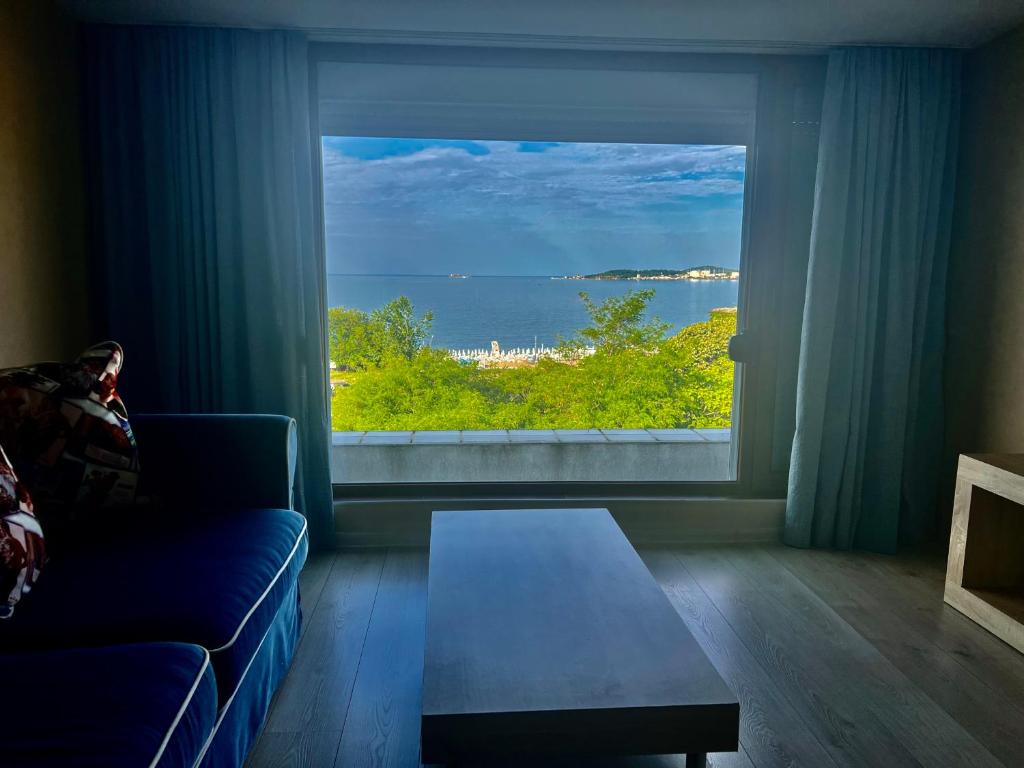 ein Wohnzimmer mit einem großen Fenster mit Meerblick in der Unterkunft Vista Sul Mare II in Burgas City