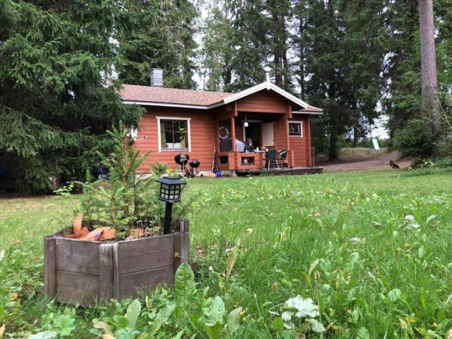 una pequeña casa roja en un campo de hierba en Holiday Cabin Kerimaa 41 en Savonlinna