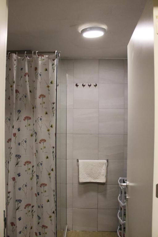 a bathroom with a shower with a shower curtain at Domini LakeView Apartment in Mavrovo