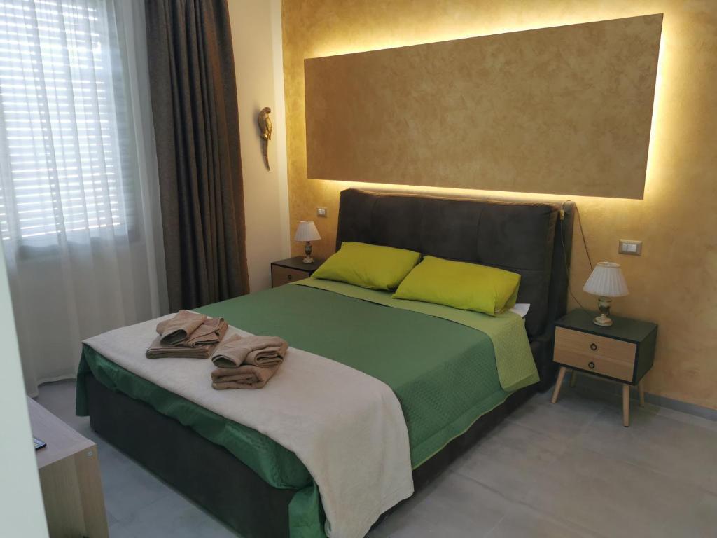 a bedroom with a green bed with towels on it at L'Anfora in Montesilvano