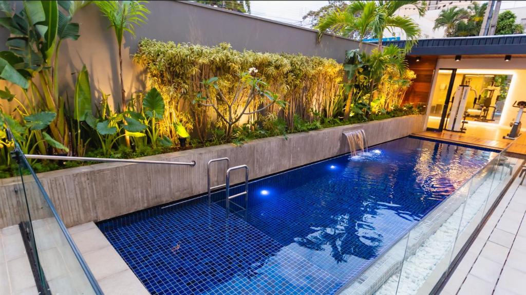 uma piscina com jardim num edifício em JR Hotel em Presidente Prudente