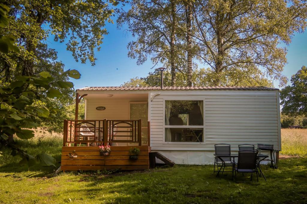 une petite maison dans une cour avec deux chaises dans l'établissement Mini-Glamping en Auvergne, à Sainte-Christine