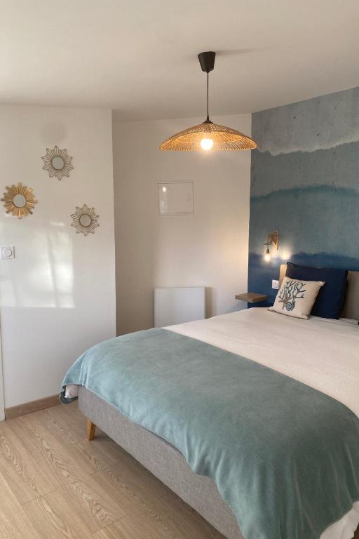 une chambre avec un grand lit avec un mur bleu dans l'établissement Le Gîte 55, à Paimpol