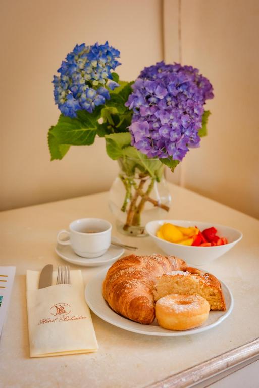 a table with a plate of bread and flowers at Hotel Belvedere in Forte dei Marmi