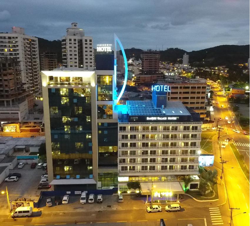 a lit up building in a city at night at Sandri Palace Hotel in Itajaí