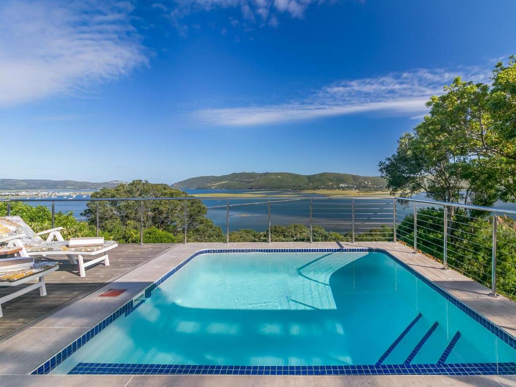 a swimming pool with a view of the water at Stunning Villa with pool and views of Knysna in Knysna