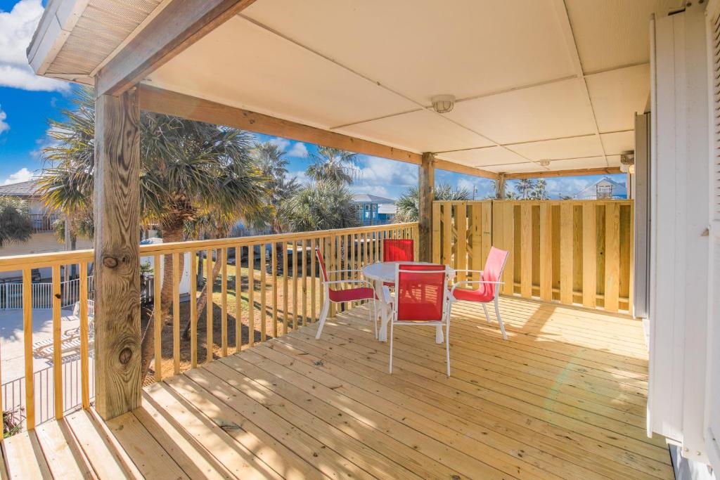 a porch with a table and chairs on a deck at Wave on Wave! Overlooking community pool! in Port Aransas