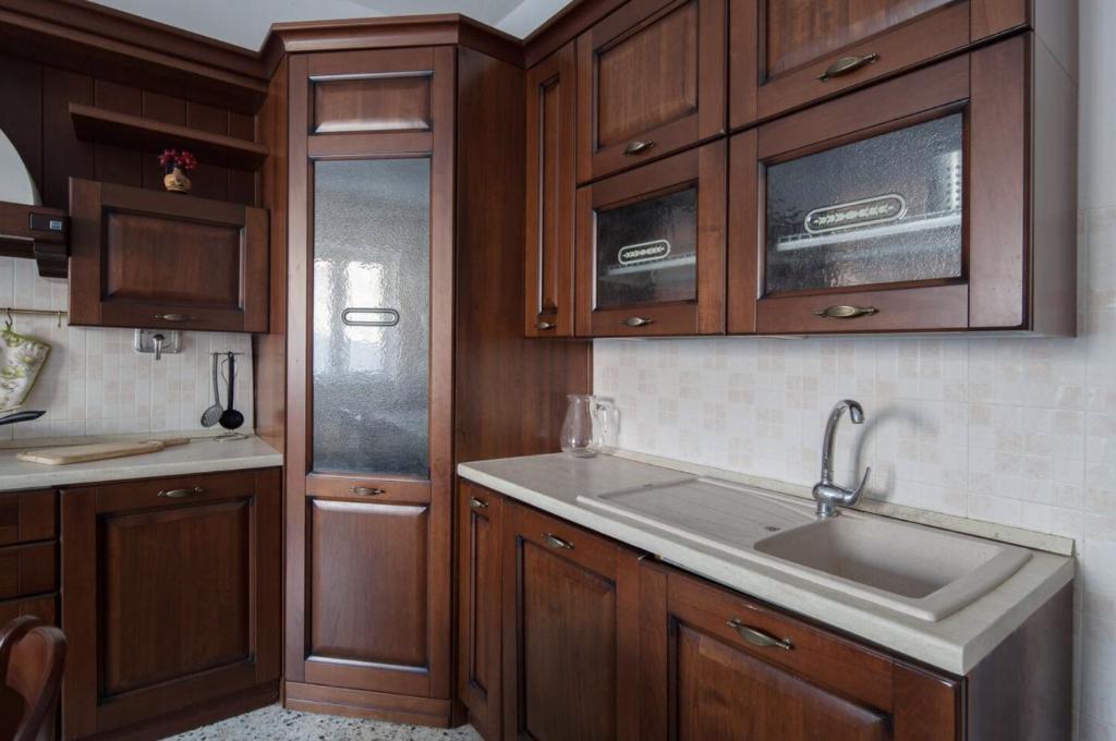 eine Küche mit Holzschränken und einem Waschbecken in der Unterkunft I Venti in Levanto