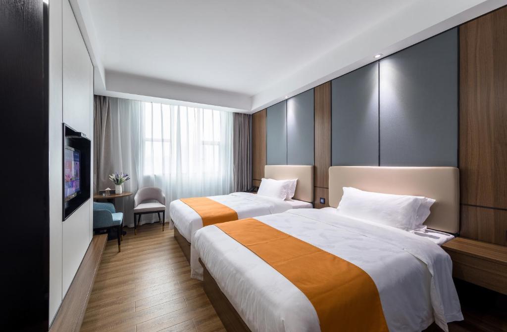ein Hotelzimmer mit 2 Betten und einem Flachbild-TV in der Unterkunft Morninginn, Qingyuan Gulong Gorge Wanda Plaza in Qingyuan
