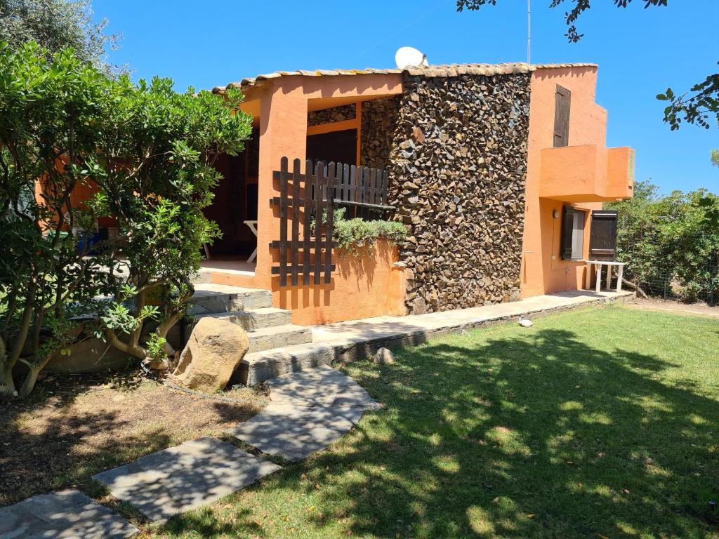 a house with a fence and a yard at Villa caposchiera a 500 metri dal mare in Villasimius