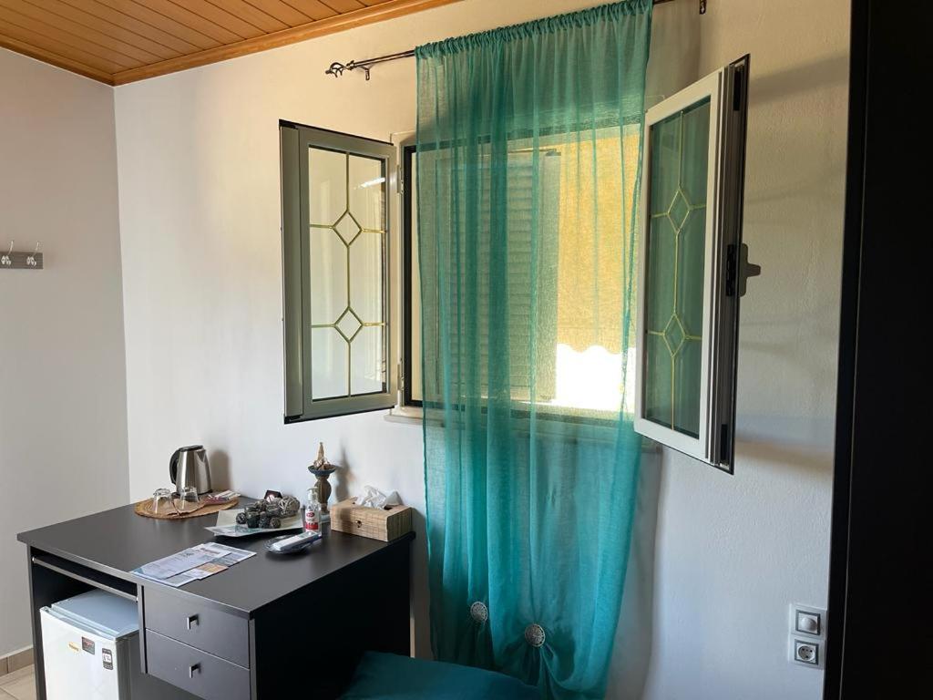 Habitación con escritorio y cortina verde. en Chania Casa Portokali, en Perivólia