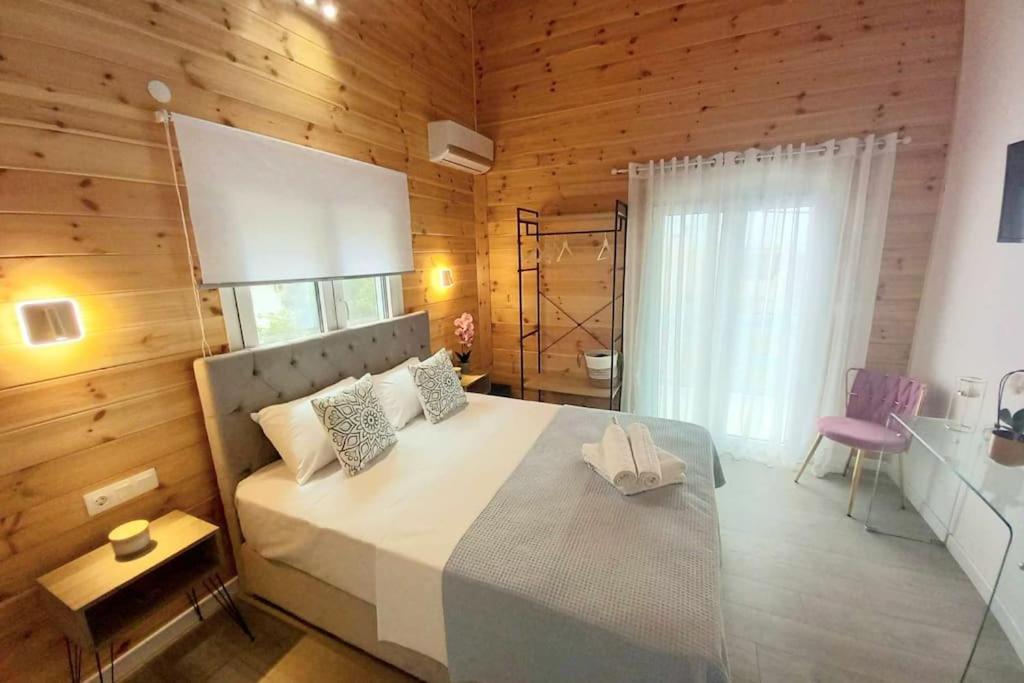 ein Schlafzimmer mit einem großen Bett und einer Holzwand in der Unterkunft Divine Studios Elafonisos B2 in Elafonisos