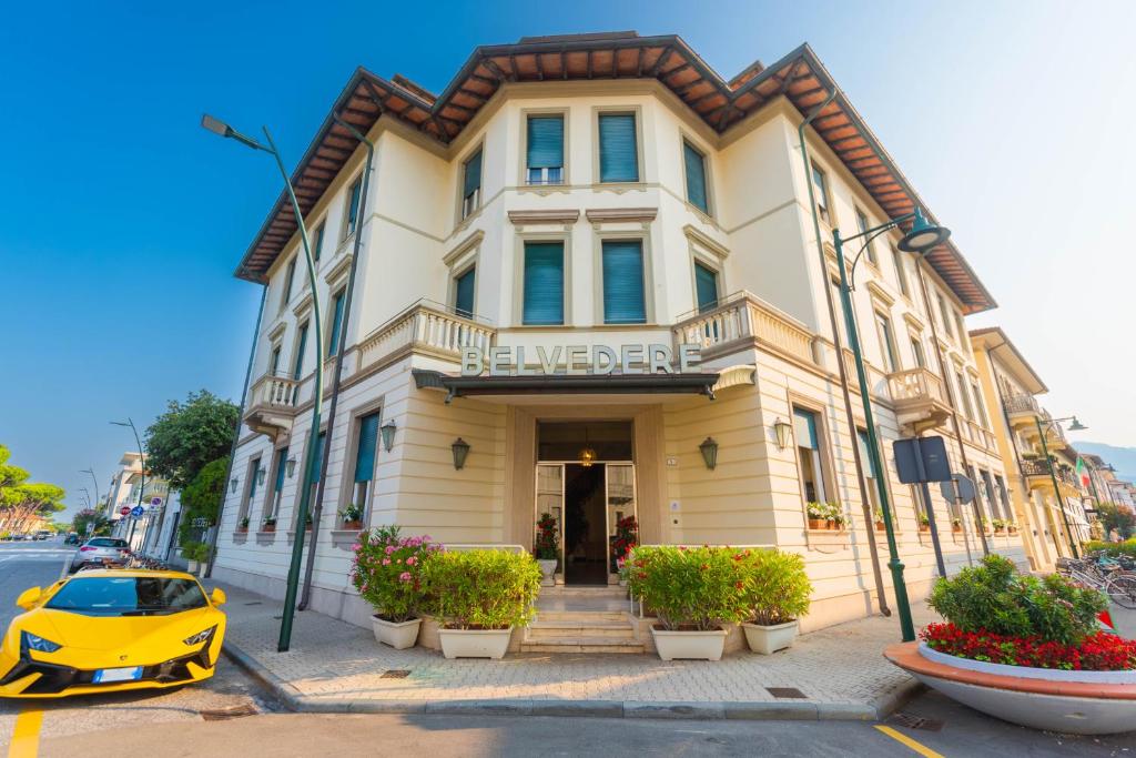 un'auto gialla parcheggiata di fronte a un edificio di Hotel Belvedere a Forte dei Marmi