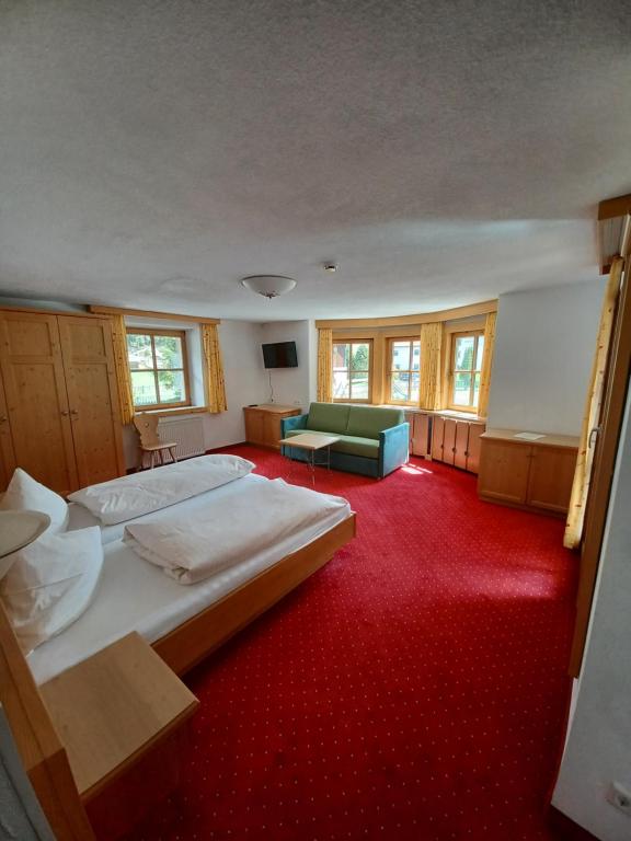 a large bedroom with two beds and a red carpet at Hotel Restaurant Liesele Sonne in Sankt Leonhard im Pitztal