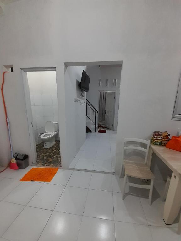 um quarto branco com um piso branco e um WC em Bumi Dieng Indah Residence em Kalianget