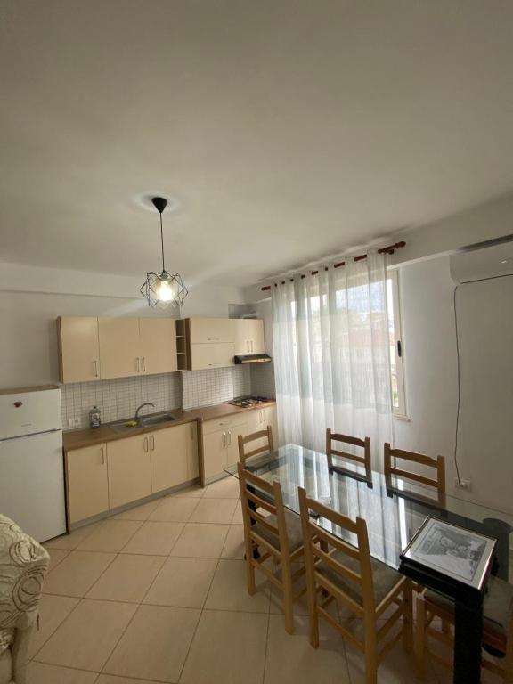 une cuisine et une salle à manger avec une table et des chaises en verre dans l'établissement Holiday Apartaments Durres, à Durrës