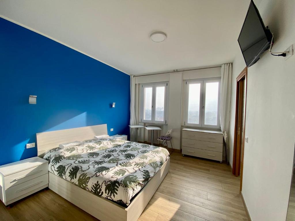 a bedroom with a bed and a blue wall at Venice Mestre Station House in Mestre