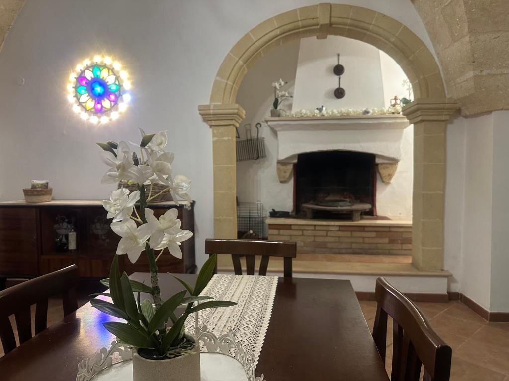 comedor con mesa y chimenea en Casa Vacanza - L’ Antica Torre, en Maruggio