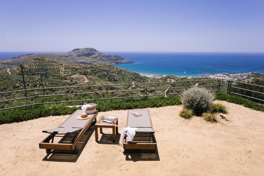 a picnic table on top of a hill with the ocean at Villa Stella Suites in Plakias