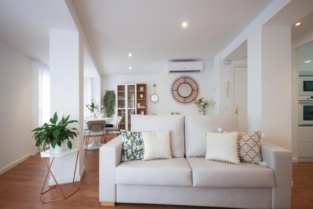 a living room with a white couch with pillows at Amage Suite in Castellón de la Plana