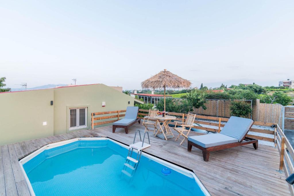 patio z basenem, stołem i krzesłami w obiekcie Alcyone Two Bedroom Country House with private pool w mieście Kavrokhórion