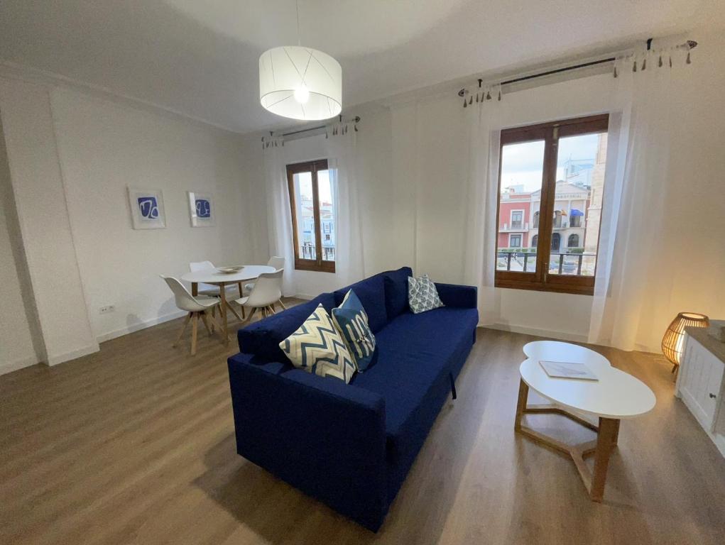 ein Wohnzimmer mit einem blauen Sofa und einem Tisch in der Unterkunft Blanco y Añil Plaza in Valdepeñas